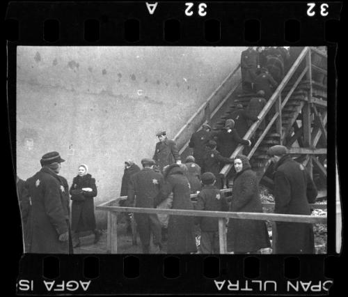 Residents walking up the stairs to the pedestrian bridge crossing Zigerska Street, the "Aryan" street that divided the ghetto into two areas