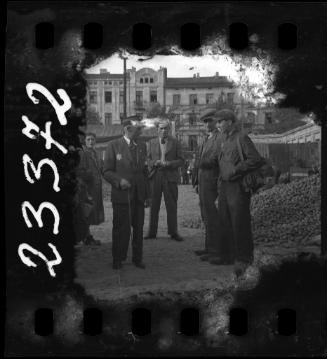 Jewish policeman talking to residents beside a pile of potatoes