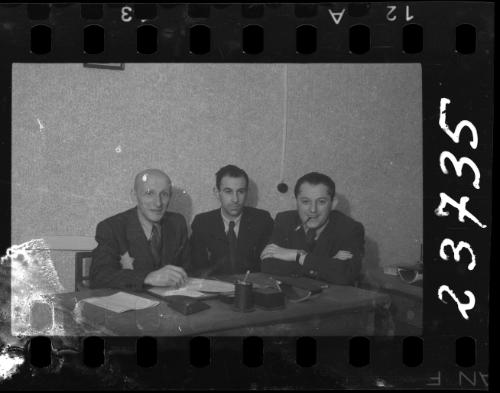 Three members of the ghetto administration sitting at a desk