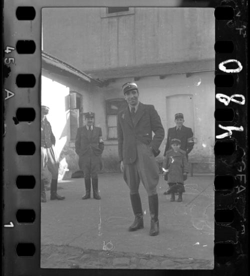 A group of Jewish policemen with a young boy, wearing policeman's hat