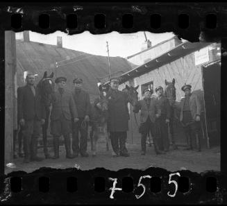 Workers of the Transport Department, standing with horses, outside a stable in the ghetto