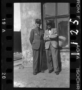 Two Jewish policemen standing beside a window