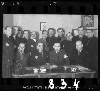Group portrait of members of the ghettto administration in an office