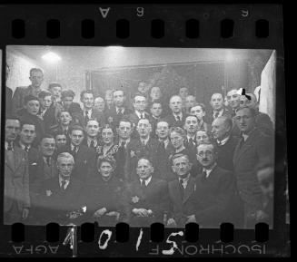 Large group portrait of well dressed men and women [probably members of the Judenrat, the Jewish Council]