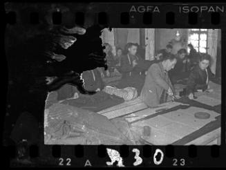 Men and women workers cutting fabric in a workshop in the ghetto