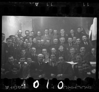 Large group portrat of men, women and children [probably members of the Judenrat, the Jewish Council, and their families]