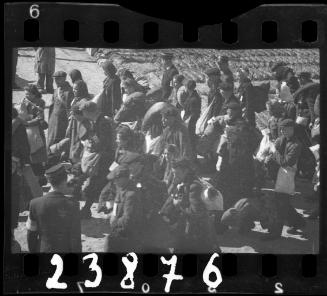 Large group of residents being deported from the ghetto, walking with their belongings