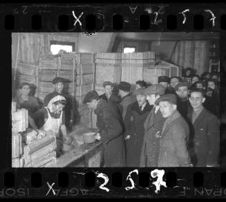 Cook ladling soup into pails for residents