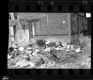 Discarded pails left behind residents sent for deportation, outside building #58