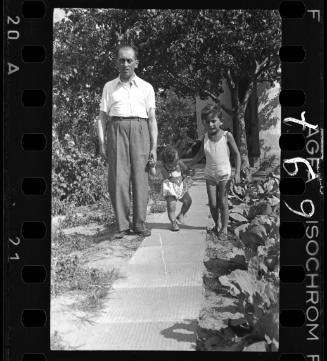 A man with a boy and a baby, walking