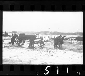Fecal workers hauling a sewage collecting tank mounted on a wagon, in winter