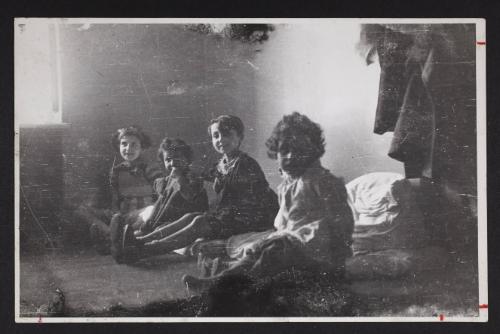 Four children sitting on floor mats