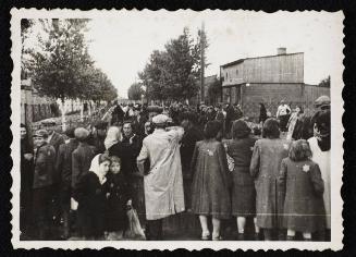Row of residents talking through fence of central prison prior to deportation