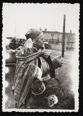 Old women in blanket with possessions, being deported to Chelmno nad Nerem death camp, Lodz Ghetto