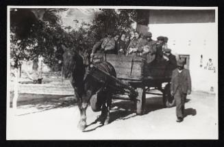 Man walking alongside horse-drawn deportation wagon carrying residents being deported from the ghetto