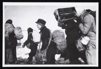 Boy in cap, with satchel and sack tied to back, walking with winter deportation crowd -side-profile