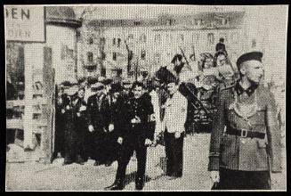 German officials at ghetto entrance with residents and 'JUDEN' sign in background