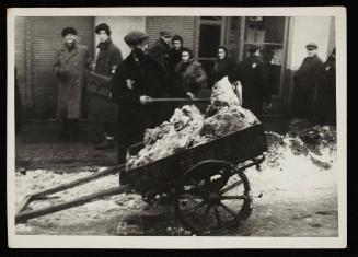 Man shovelling snow onto cart